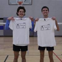 Students holding up championship shirts from a badminton tournament